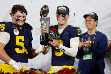 Mason Graham #55 and J.J. McCarthy #9 of the Michigan Wolverines celebrate with The Leishman Trophy 