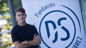 Denis Suárez, jugador del Villarreal, posa delante del logotipo de la Fundación Denis Suárez.