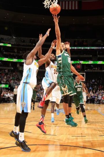 Jerryd Bayless de Milwaukee Bucks ante Emmanuel Mudiay y Kenneth Faried de Denver Nuggets.