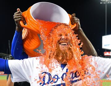 Justin Turner, tercer base de los ?ngeles Dodgers, es empapado con gatorade por Yasiel Puig despu¨¦s de dar un pase
