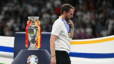 (FILES) England's head coach Gareth Southgate walks with his silver medal past to the trophy after the UEFA Euro 2024 final football match between Spain and England at the Olympiastadion in Berlin on July 14, 2024. Gareth Southgate said he is reg as England manager on July 16, 2024 two days after they lost to Spain in the Euro 2024 final. "It's time for change, and for a new chapter. Sunday's final in Berlin against Spain was my final game as England manager," he said in statement. (Photo by JAVIER SORIANO / AFP)