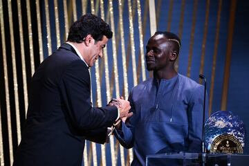 El delantero senegal谷s del Bayern, Sadio Mane, recibe el Trofeo S車crates al jugador m芍s involucrado en proyectos sociales y caritativos de manos del ex futbolista franco-brasile?o Rai en la ceremonia de entrega de premios del Bal車n de Oro 2022.