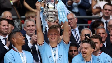 Manchester City's Norwegian striker Erling Haaland (C) lifts the trophy after the English FA Cup final football match between Manchester City and Manchester United at Wembley stadium, in London, on June 3, 2023. (Photo by Adrian DENNIS / AFP) / NOT FOR MARKETING OR ADVERTISING USE / RESTRICTED TO EDITORIAL USE