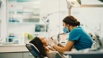 Female dentist examining young woman's teeth.