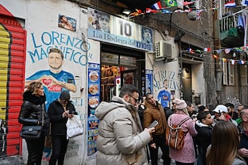 Turistas paseando por los murales de  Quartieri Spagnoli, en el centro de Nápoles, dedicados a los jugadores del Nápoles Insigne, Mertnes, y especialmente Diego Armando Maradona.