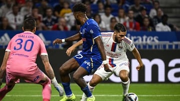 Lyons French midfielder Rayan Cherki (R) fights for the ball with Troyes French defender Yoann Salmier (C) as Troyes' French goalkeeper Gauthier Gallon (L) looks on during the French L1 football match between Olympique Lyonnais (OL) and ES Troyes AC at The Groupama Stadium in Decines-Charpieu, central-eastern France on August 19, 2022. (Photo by JEFF PACHOUD / AFP) (Photo by JEFF PACHOUD/AFP via Getty Images)