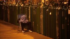 A person sleeps next to empty oxygen tanks to save a spot in the queue, as the supplier refills a tank per person and attends only up to 60 people a day, during the outbreak of the coronavirus disease (COVID-19), in Callao, Peru February 4, 2021. Picture taken February 4, 2021. REUTERS/Sebastian Castaneda