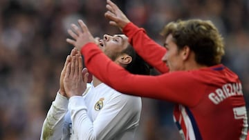 Atletico Madrid's French forward Antoine Griezmann (R) gestures as Real Madrid's Welsh forward Gareth Bale reacts after missing a goal opportunity during the Spanish league football match between Real Madrid CF and Club Atletico de Madrid at the