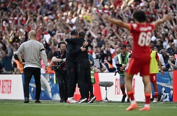 Guardiola acude a felicitar a Klopp mientras éste se abraza a un miembro de su staff.