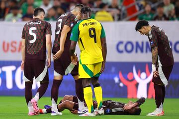 HOUSTON, TEXAS - JUNE 22: Edson Alvarez of Mexico lies down at pitch while his teammates aids him during the CONMEBOL Copa America 2024 Group B match between Mexico and Jamaica at NRG Stadium on June 22, 2024 in Houston, Texas.   Hector Vivas/Getty Images/AFP (Photo by Hector Vivas / GETTY IMAGES NORTH AMERICA / Getty Images via AFP)