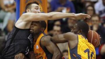 El alero del Valencia Basket, Romain Sato, junto a su compañero, el base Oliver Lafayette (c), pugna por el balón con el ala-pívot del Bilbao Basket, Axel Hervelle.