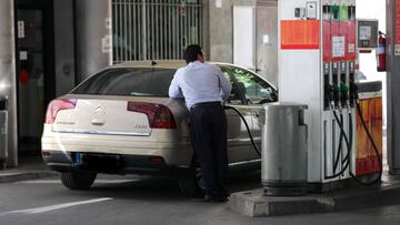 Personas ponen gasolina en sus coches en una gasolinera de Madrid.