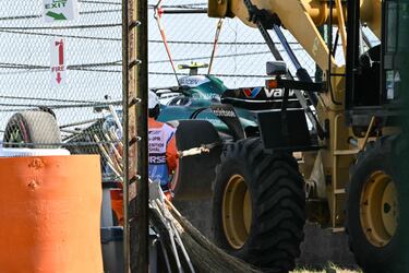 Los comisarios retiran el coche del piloto español Fernando Alonso después de quedarse atrapado en la grava en la segunda sesión de prácticas del Gran Premio de Japón de Fórmula Uno en el circuito de Suzuka en Suzuka.