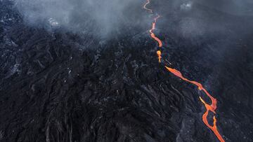 LA PALMA, SPAIN - NOVEMBER 10: Lava flows past buildings sitting under the Cumbre Vieja volcano as it continues to erupt on November 10, 2021 in La Palma, Spain. The volcano has been erupting since September 19, 2021 after weeks of seismic activity, resul