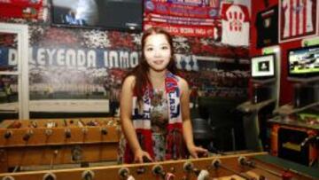 ATLÉTICA. Chang Xu juega al futbolín en el bar del Vicente Calderón con la bufanda de su mayor ídolo, Fernando Torres.