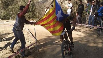 Un espectador tapa con una estelada a Carlos Coloma durante la disputa de la Copa Catalana de MTB en Banyoles.