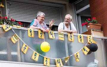 Aficionados animando al pelotón desde el balcón de su casa en el pueblo de Macon.