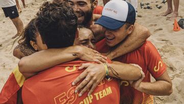 Equipo espa&ntilde;ol de SUP abraz&aacute;ndose en la playa.