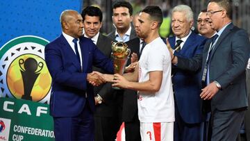 (FILES) In this file photo taken on May 26, 2019 Egypt&#039;s Zamalek player Hazem Emam (C) receives the trophy from the president of the African Football Federation Ahmed Ahmed (L) after they won the CAF Confederation Cup final football match between Egy