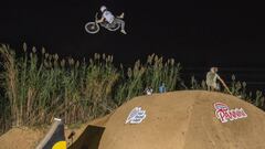 El piloto de MTB Bienvenido Aguado saltando con su bici en el Big Bertha, el gran salto de tierra del Happy Ride Weekend 2020, adornado con los logos de Premi&agrave; de Dalt, Pannini y Red Bull, con varios fot&oacute;grafos trabajando. Octubre del 2020. 