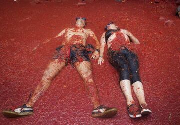 Revellers covered in tomato pulp take part in the annual "Tomatina" festival in the eastern town of Bunol, on August 30, 2017.
The iconic fiesta -- which celebrates its 72nd anniversary and is billed at "the world's biggest food fight" -- has become a major draw for foreigners, in particular from Britain, Japan and the United States. / AFP PHOTO / JAIME REINA