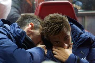 Leo Messi y Neymar conversan en el banquillo.