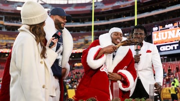LANDOVER, MARYLAND - DECEMBER 25: Trevon Diggs #7 of the Dallas Cowboys eats a steak as Michael Irvin reacts after Dallas' 30-23 victory against the Washington Commanders at Northwest Stadium on December 25, 2025 in Landover, Maryland. Scott Taetsch/Getty Images/AFP (Photo by Scott Taetsch / GETTY IMAGES NORTH AMERICA / Getty Images via AFP)