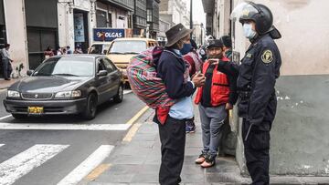 A police officer prevents a man from getting near the Congress in Lima on September 18, 2020 as Peru's President Martin Vizcarra faces an impeachment trial. - Vizcarra faces an impeachment trial in congress on Friday after Peru's top court rejected his government's appeal to block the vote, though analysts said he would likely survive. The Constitutional Court ruled by five votes to two to allow the vote, its president announced in a statement which acknowledged that in any case, Vizcarra's removal appeared increasingly remote. (Photo by Ernesto BENAVIDES / AFP)