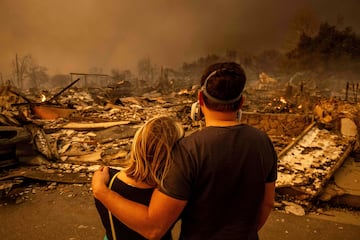 Megan Mantia, a la izquierda, y su novio Thomas, regresan a la casa de Mantia, dañada por el fuego.