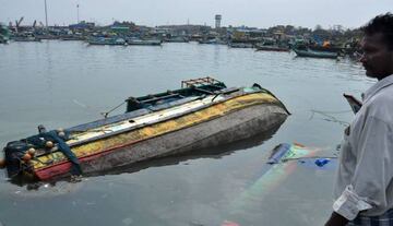 A Indian fisherman surveys damaged boats at a harbour in Chennai on December 13, 2016.