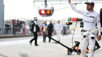 Fernando Alonso saludando a la afici¨®n china tras bajarse del McLaren en la calificaci¨®n.