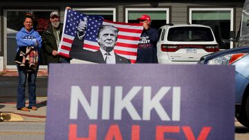 Men hold a U.S. flag with a photo of Donald Trump, as Republican presidential candidate and former U.S. Ambassador to the United Nations Nikki Haley makes a campaign stop ahead of the South Carolina Republican presidential primary election in Moncks Corner, South Carolina, U.S. February 23, 2024. REUTERS/Brian Snyder