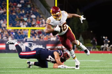 FOXBOROUGH, MA - AUGUST 12: Jonathan Williams #38 of the Washington Football Team avoids the tackle from Cassh Maluia #44 of the New England Patriots in the second half at Gillette Stadium on August 12, 2021 in Foxborough, Massachusetts. Kathryn Riley/Get