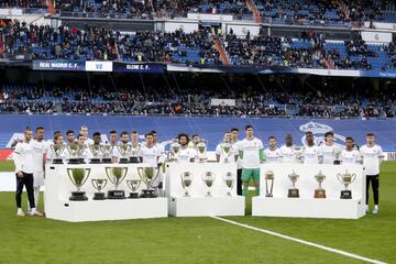 Sentido homenaje en el Santiago Bernab¨¦u a Paco Gento, antes del inicio de partido. Los jugadores del Real Madrid posan con todos los trofeos conseguidos por Gento.