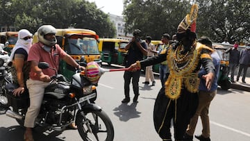 A volunteer of District Magistrate (DM) office dressed as Yamraj, or Hindu God of death, stops people for not wearing masks, amidst the spread of the coronavirus(COVID-19) disease, in New Delhi, India, September 28, 2020. REUTERS/Anushree Fadnavis