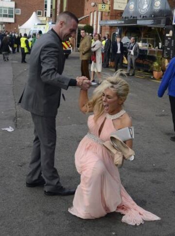 Una aficionada recibe ayuda tras caer al suelo en Aintree.