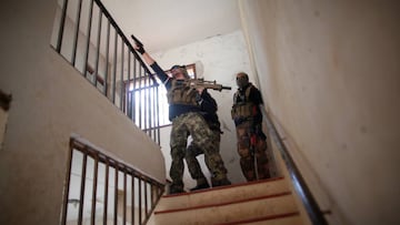 A player depicting an Islamic State militant fires his airsoft gun inside a ruined house during an airsoft game against players depicting soldiers from the U.S.-led coalition forces in Coin, near Malaga, southern Spain April 23, 2017. Picture taken April 23, 2017. REUTERS/Jon Nazca