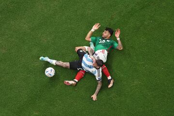 El jugador argentino Rodrigo De Paul y el jugador mexicano Alexis Vega, acaban en el suelo tras la disputa de un balón. 

