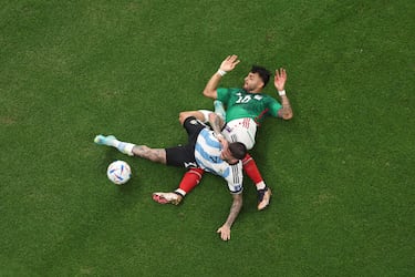 El jugador argentino Rodrigo De Paul y el jugador mexicano Alexis Vega, acaban en el suelo tras la disputa de un balón. 

