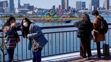 Turistas se fotografían frente al anillo olímpico de Tokio 2020.