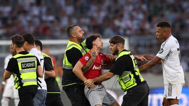 Imagen de un aficionado intentando llegar a Mbappé y frenado por la seguridad del estadio Tivoli.