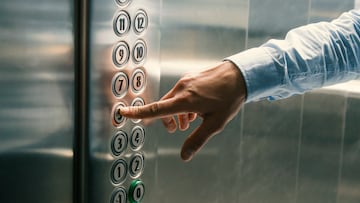 Finger pressing the button in the elevator