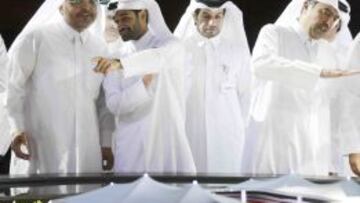 Miembros de la candidatura de Qatar observan una maqueta de lo que ser&aacute; uno de los estadios que albergar&aacute;n el Mundial 2022.  
 