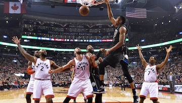 Milwaukee Bucks forward Giannis Antetokounmpo, top, dunks the ball past Toronto Raptors center Jonas Valanciunas (17) during the first half in the first round of the NBA basketball playoffs in Toronto, Saturday, April 15, 2017. (Nathan Denette/The Canadian Press via AP)