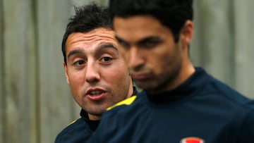 Arsenal's Santi Cazorla (L) talks to team mate Mikel Arteta as they arrive for a team training session in London Colney, north of London October 23, 2012. Arsenal are due to play Schalke 04 in their Champions League match in London on Wednesday. REUTERS/ Eddie Keogh (BRITAIN - Tags: SPORT SOCCER)