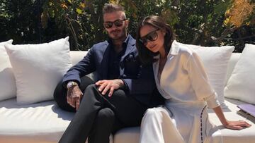 David y Victoria Beckham sentados en un sofá al aire libre.