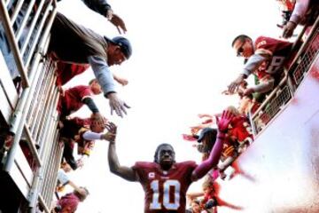 Robert Griffin III de los Washington Redskins celebra con los aficionados la victoria contra los Chicago Bears.