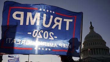 Un partidario del presidente Donald Trump sostiene una bandera Trump 2020 frente al edificio del Capitolio de los Estados Unidos mientras asisten a marchas pro Trump, el s&aacute;bado 14 de noviembre de 2020 en Washington.