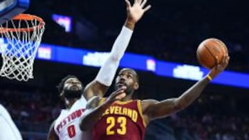 Andre Drummond trata de frenar la entrada de LeBron James.