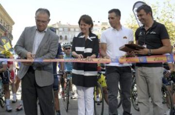 GRA266. PAMPLONA (NAVARRA) 03/09/2014.- El alcalde de Pamplona, Enrique Maya (i) procede al corte de cinta, junto a la presidenta del Gobierno de Navarra, Yolanda Barcina y el pentacampeón del Tour de Francia, Miguel Induráin (2d), a la salida hoy de la Plaza del Castillo de Pamplona donde ha dado comienzo la undécima estapa que tendrá final en el alto del Santuario de San Miguel de Aralar. EFE/Villar López